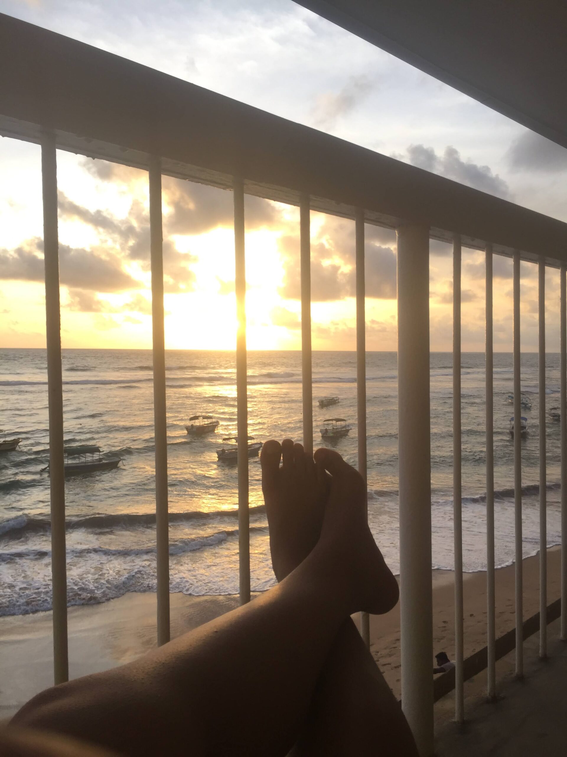 Woman's feet up watching Sri Lanka sunset while travelling