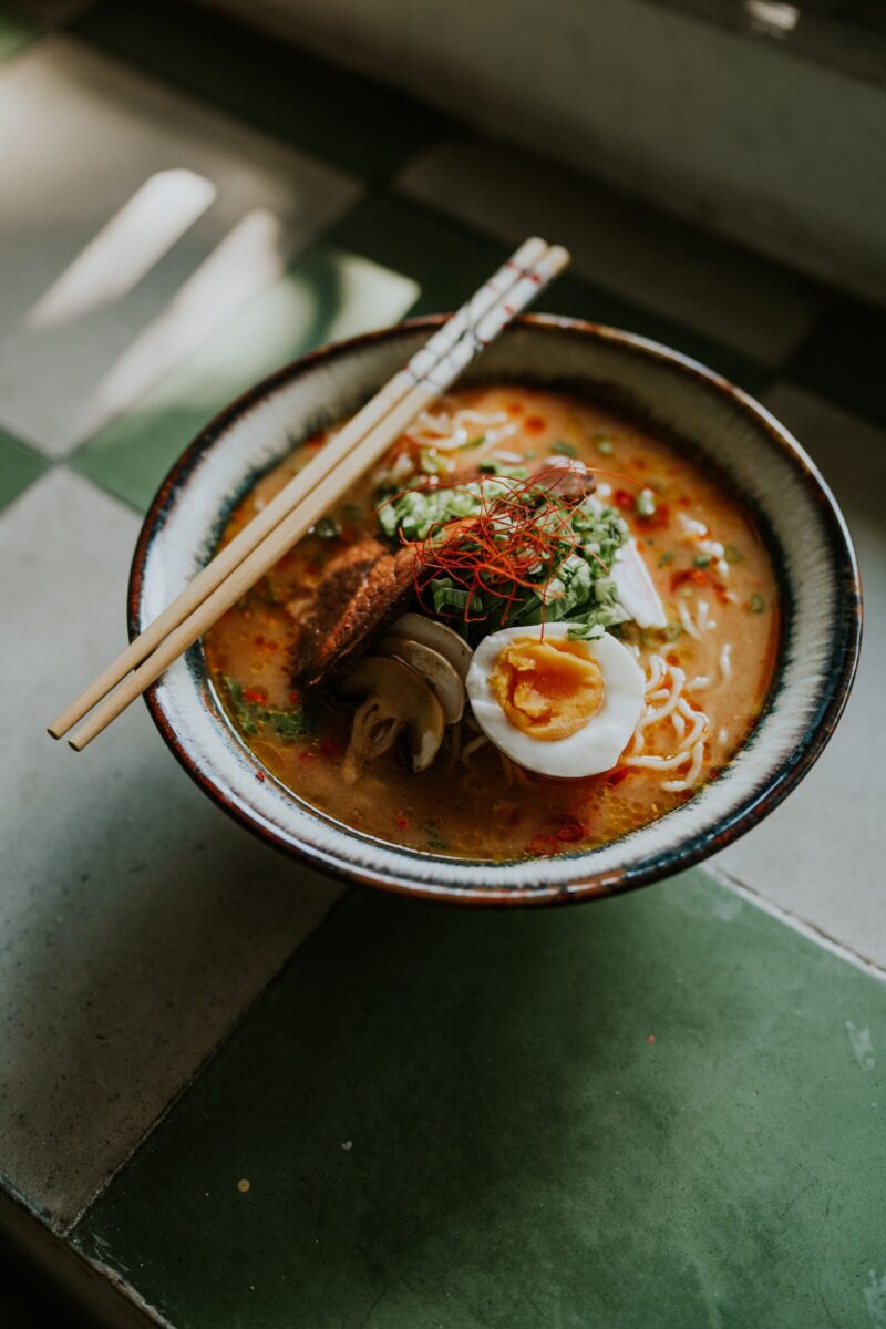 Top view of a flavorful ramen bowl with egg and chopsticks, perfect for food lovers.